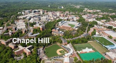 Aerial view of Chapel Hill, NC, highlighting the university campus, sports fields, and lush green surroundings